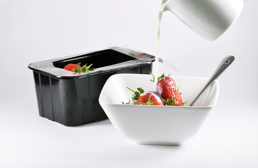 cream being poured on strawberries